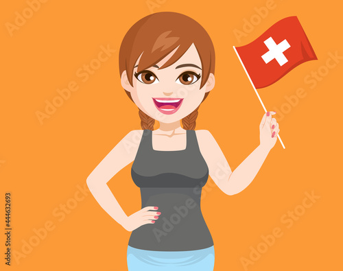 Beautiful young Swiss woman smiling with hand on hip holding and waving Switzerland flag