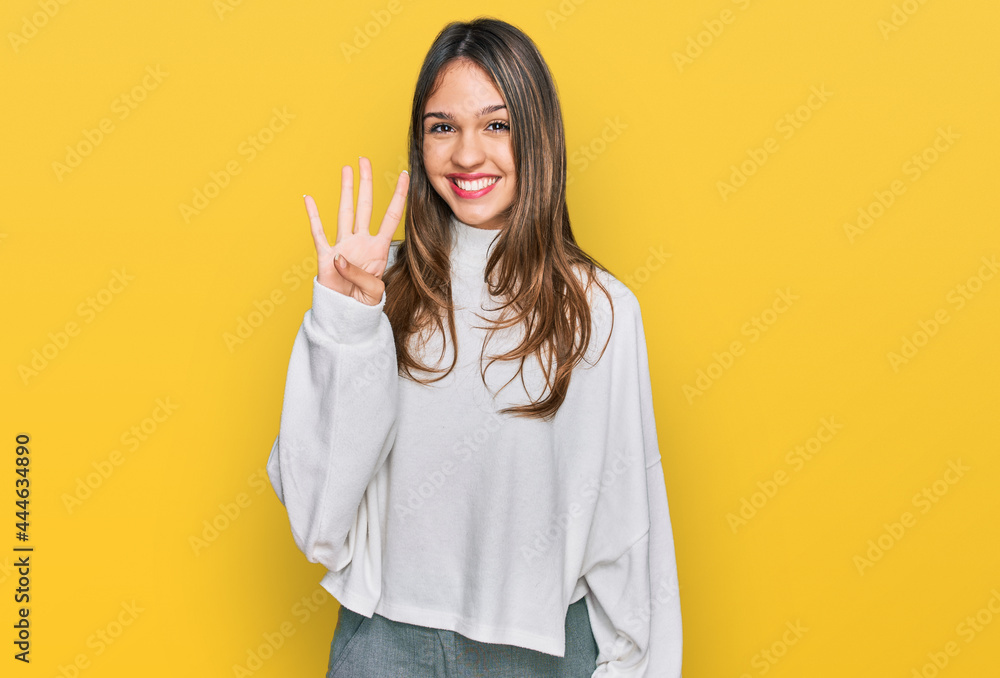 Young brunette woman wearing casual turtleneck sweater showing and pointing up with fingers number four while smiling confident and happy. Young brunette woman wearing casual turtleneck sweater showing and pointing up with fingers number four while smiling confident and happy.
