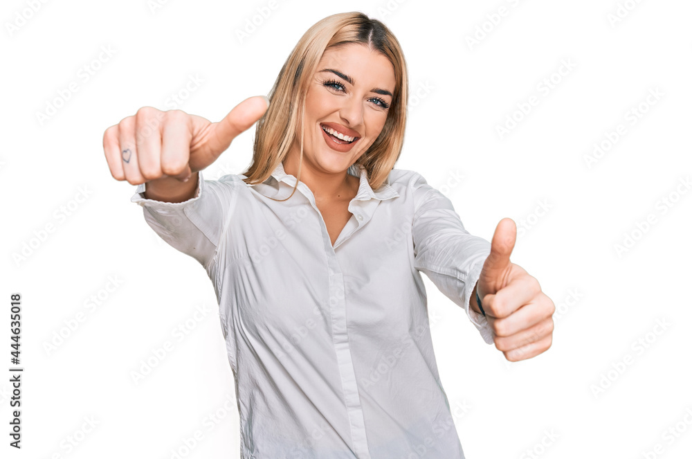 Young caucasian woman wearing casual clothes approving doing positive gesture with hand, thumbs up smiling and happy for success. winner gesture. Young caucasian woman wearing casual clothes approving doing positive gesture with hand, thumbs up smiling and happy for success. winner gesture.