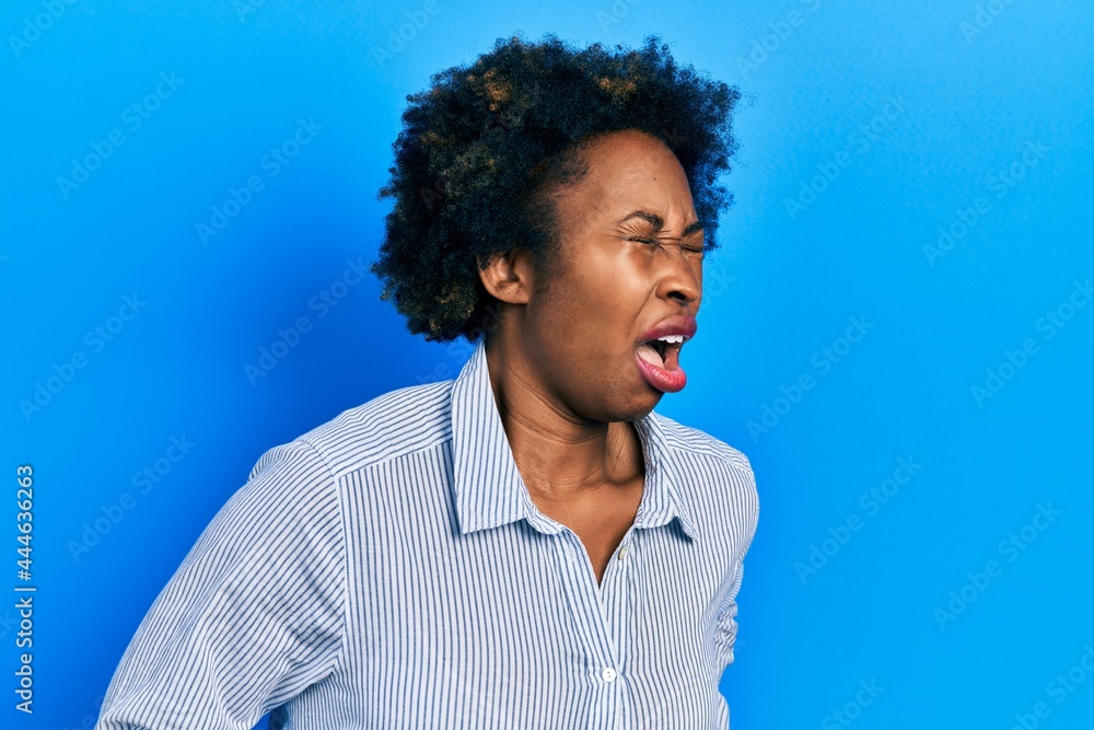 Young african american woman wearing casual clothes with hand on stomach because nausea, painful disease feeling unwell. ache concept. Young african american woman wearing casual clothes with hand on stomach because nausea, painful disease feeling unwell. ache concept.