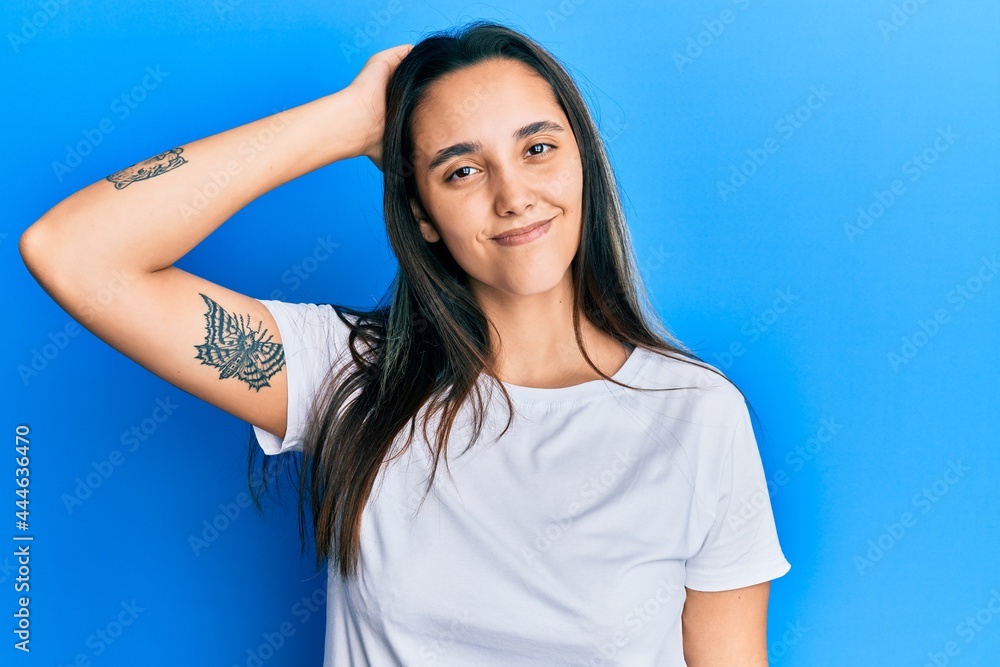 Young hispanic woman wearing casual white t shirt confuse and wonder about question. uncertain with doubt, thinking with hand on head. pensive concept. Young hispanic woman wearing casual white t shirt confuse and wonder about question. uncertain with doubt, thinking with hand on head. pensive concept.