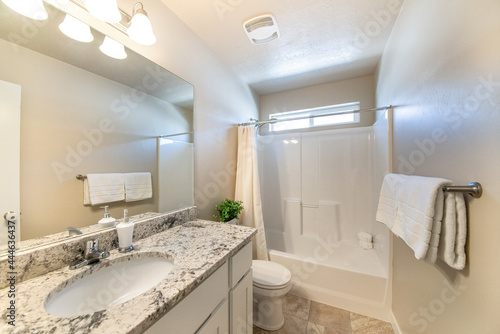 Small plain white bathroom with vanity and bathtub
