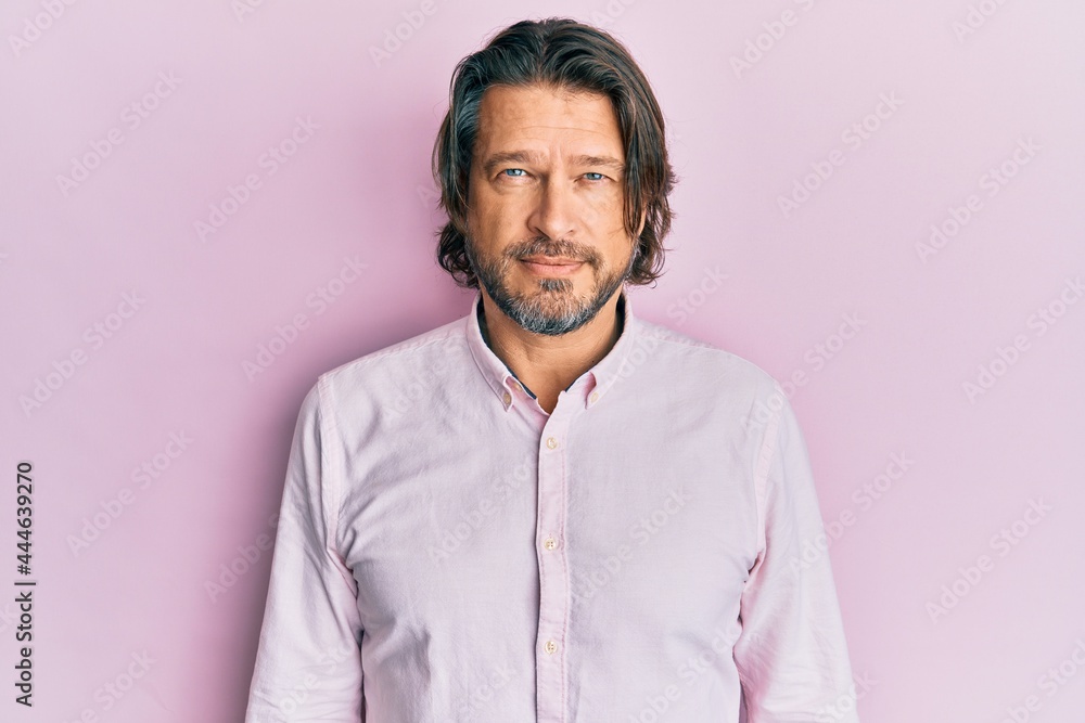 Middle age handsome man wearing business shirt with serious expression on face. simple and natural looking at the camera. Middle age handsome man wearing business shirt with serious expression on face. simple and natural looking at the camera.