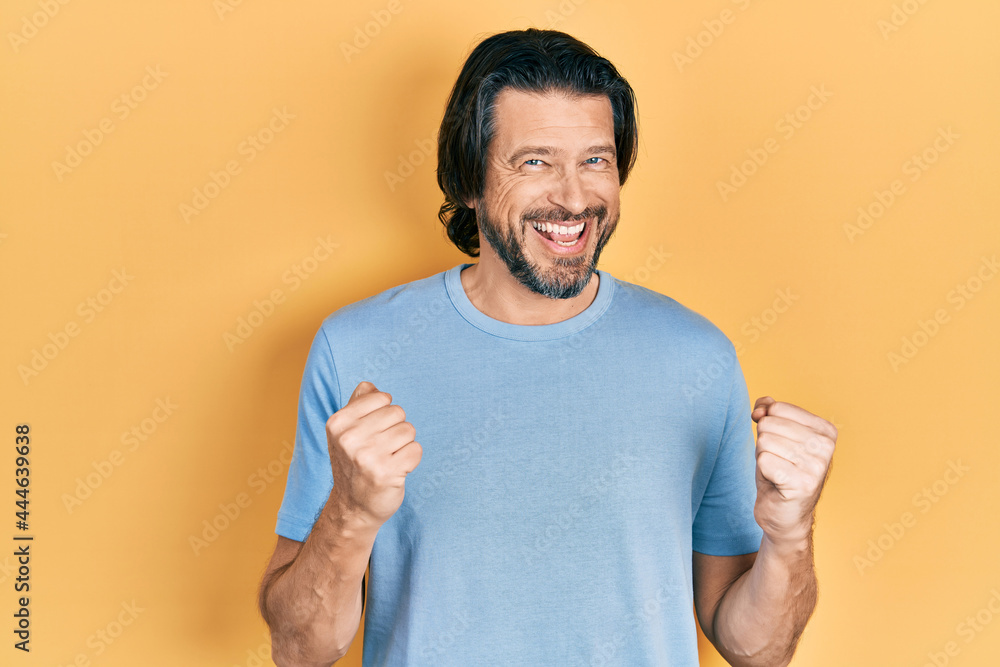 Middle age caucasian man wearing casual clothes excited for success with arms raised and eyes closed celebrating victory smiling. winner concept. Middle age caucasian man wearing casual clothes excited for success with arms raised and eyes closed celebrating victory smiling. winner concept.
