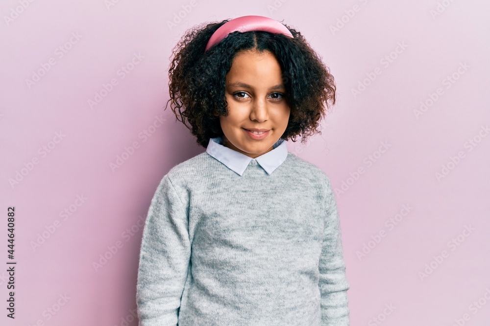 Young little girl with afro hair wearing casual clothes looking positive and happy standing and smiling with a confident smile showing teeth Young little girl with afro hair wearing casual clothes looking positive and happy standing and smiling with a confident smile showing teeth
