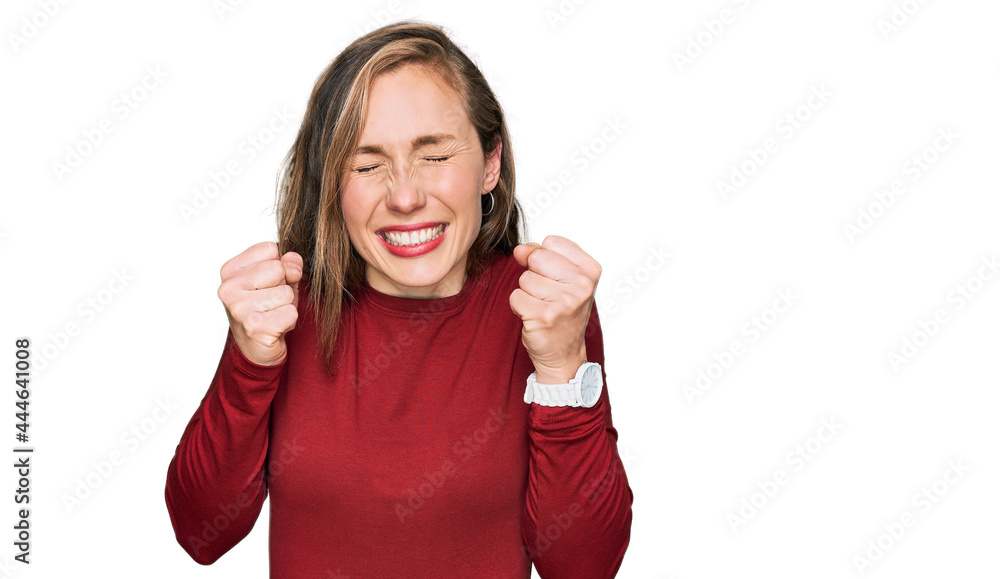 Young blonde woman wearing casual clothes excited for success with arms raised and eyes closed celebrating victory smiling. winner concept. Young blonde woman wearing casual clothes excited for success with arms raised and eyes closed celebrating victory smiling. winner concept.