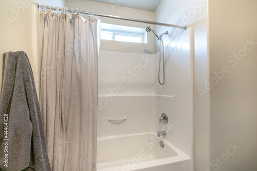 Bathroom interior with tub shower combo and window