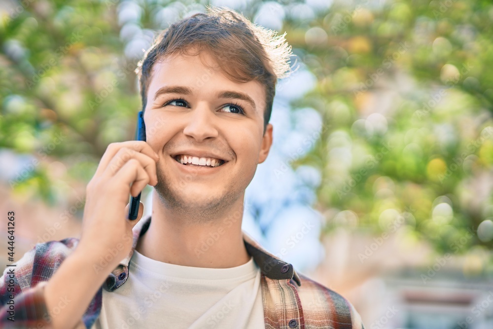 Young caucasian man smiling happy talking on the smartphone at the city. Young caucasian man smiling happy talking on the smartphone at the city.