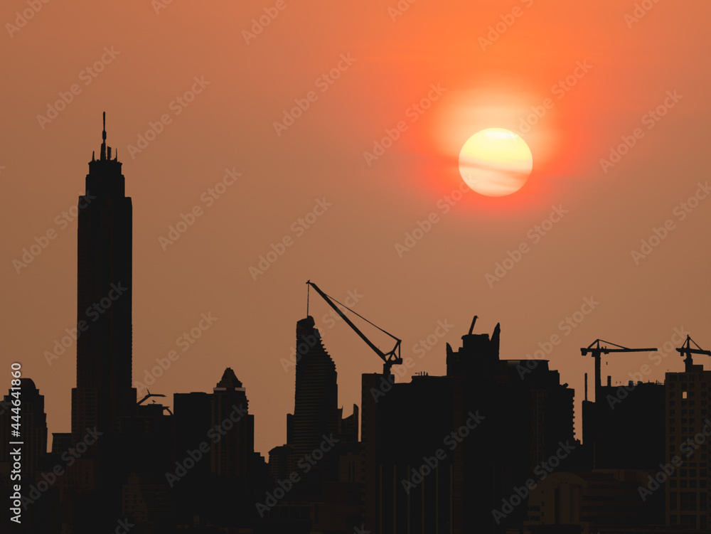 silhouette of construction site with tower crane during sunset
