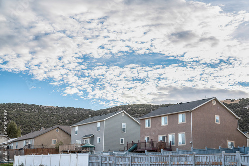 Large two-storey houses with front door decks with a view of mountains and sky