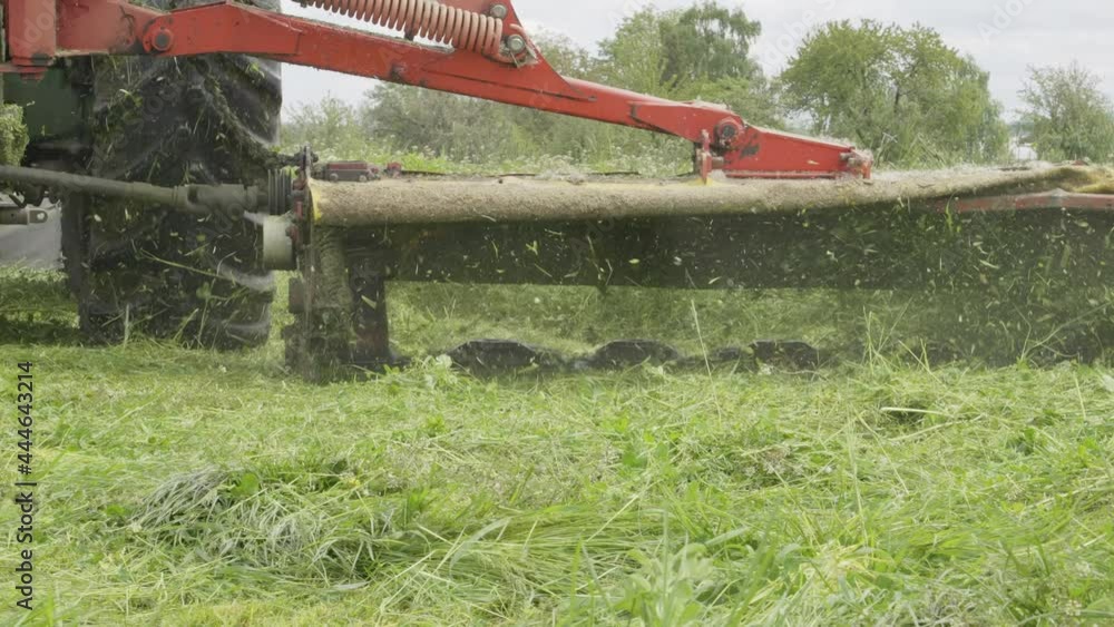 Close Up, Lawn Mower Attached to Tractor, Machine Harvesting Grass. Slow Motion Close Up, Lawn Mower Attached to Tractor, Machine Harvesting Grass. Slow Motion