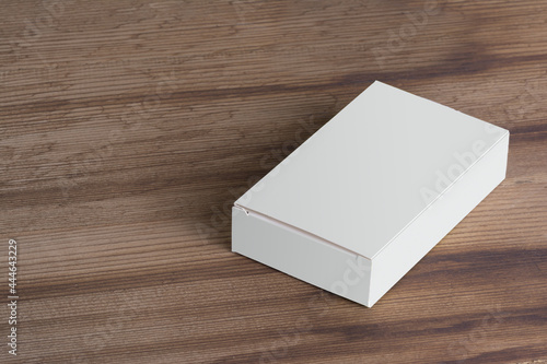 фотографія Blank white pillbox of suppositories loaf on a wooden surface - editable mockup