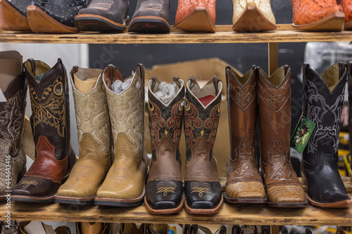 Decorative cowboy boots for sale on a plank of wood