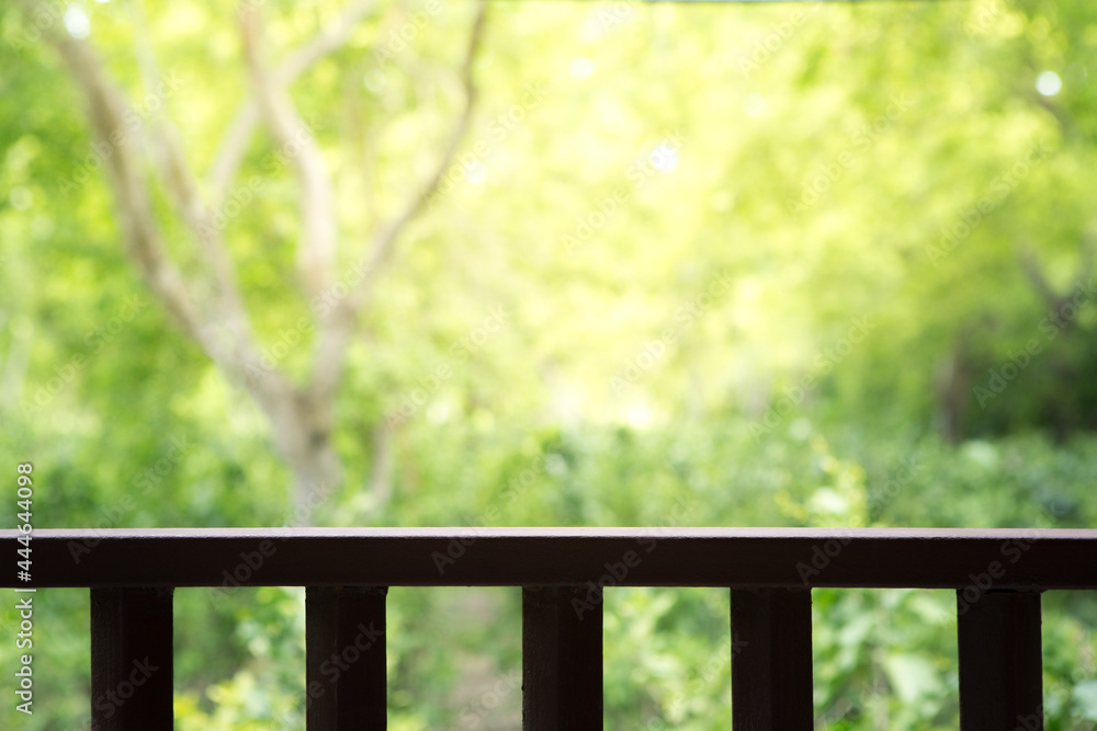 Fototapeta premium Wooden slatted balcony on natural blurred background with sunlight