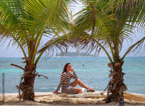Obraz na płótnie Woman on the beach between two palm trees w salonie