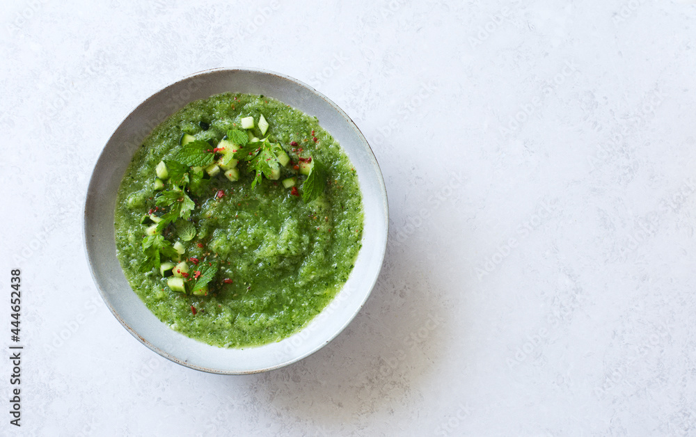 Cucumber gazpacho. Green cold cucumber cilantro celery soup in gray bowl on gray stone background. Flat lay. Copy space Cucumber gazpacho. Green cold cucumber cilantro celery soup in gray bowl on gray stone background. Flat lay. Copy space