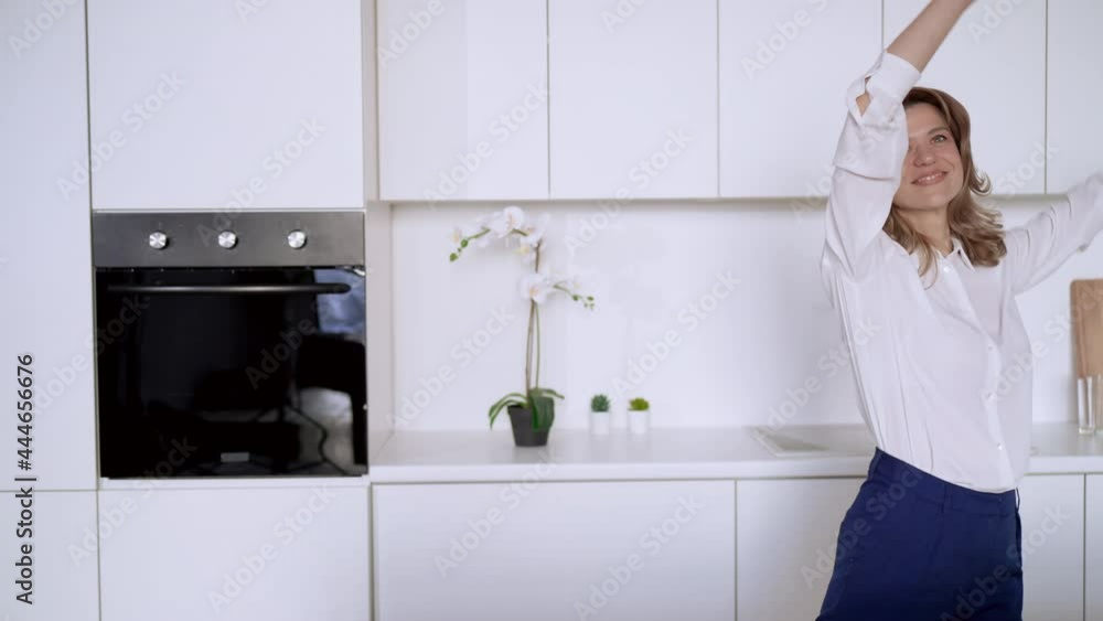 middle aged caucasian woman dancing on the kitchen with white interior at home slow motion middle aged caucasian woman dancing on the kitchen with white interior at home slow motion