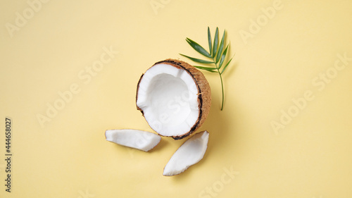 Eco friendly flat lay. Fresh coconut and slices on yellow background. Healthy and vegan food. Top view and copy space
