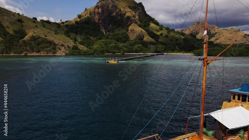 Aerial View Of A Wooden Boat At The Blue Waterscape Of Flores Sea With Coastal Hills At Komodo. East Indonesia. photo