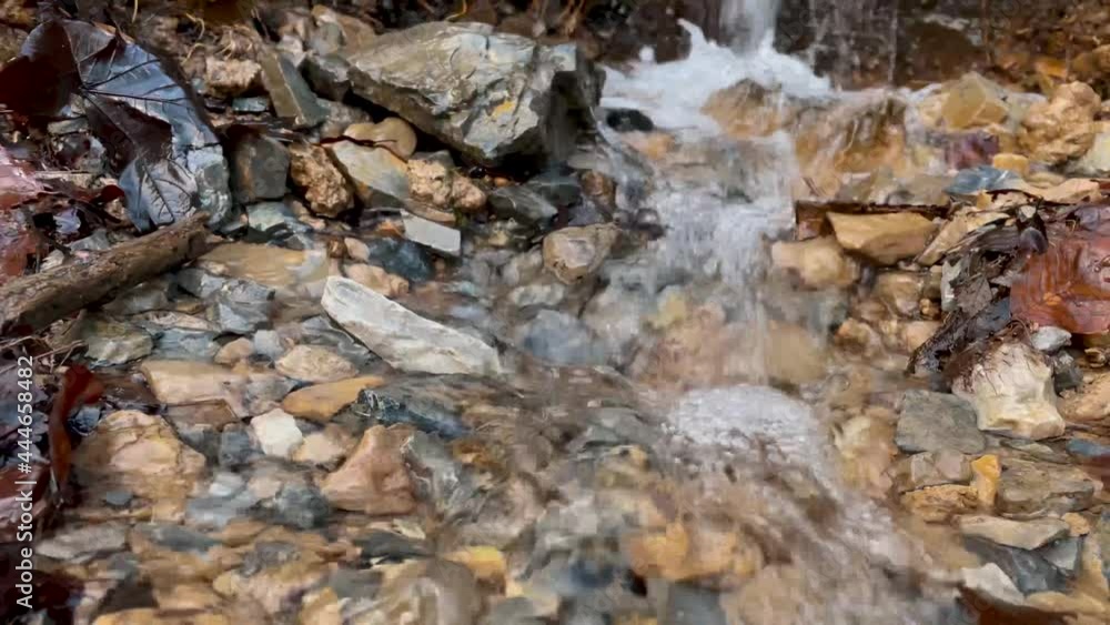Little clear mountain brook flowing among gravels. Close-up. Little clear mountain brook flowing among gravels. Close-up.