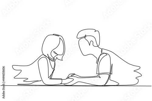Continuous one line drawing side view of beautiful young couple holding hands, looking at each other and smiling while lying on floor at home. Single line draw design vector graphic illustration