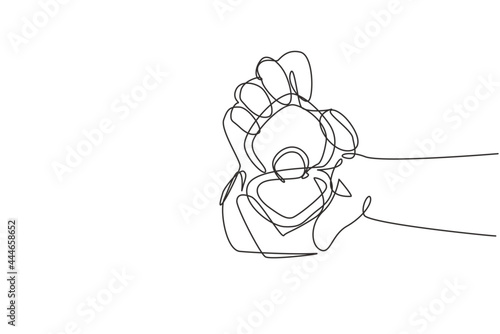 Single one line drawing hand holding ring box as an engagement symbol. Groom's gift for bride on their special day. Marriage celebration. Modern continuous line draw design graphic vector illustration