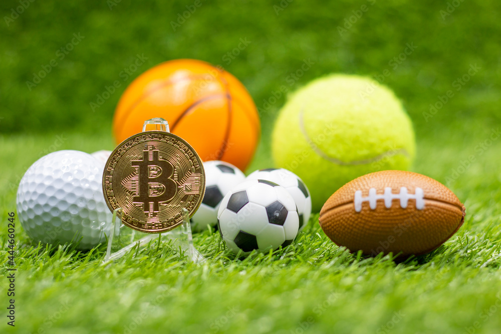 Naklejka premium Bitcoin with soccer ball are on green grass for betting concept with sport