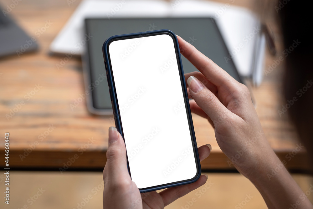 Close-up of woman using a smartphone blank white screen at the office. Close-up of woman using a smartphone blank white screen at the office.