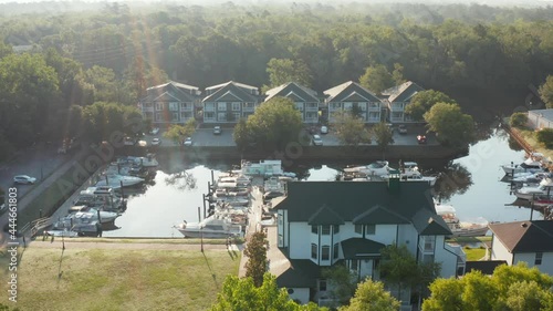 Homes at boat dock pier in Conway South Carolina. Aerial as people walk from homes in morning sunshine. photo