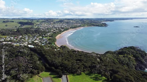 Rising aerial drone of Coopers Beach township and stunning curved bay Doubtless Bay, Northland in New Zealand, Aotearoa photo