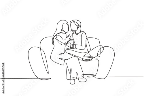 Single continuous line drawing romantic Arabian couple sitting relaxed together on sofa, woman feeding popcorn to man. Celebrate wedding anniversary. One line draw graphic design vector illustration