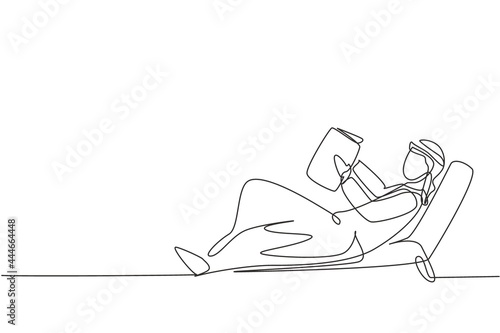 Single continuous line drawing young Arab man reading, learning and laying down on recliner sofa. Literature fans or lovers. Education concept. Dynamic one line draw graphic design vector illustration