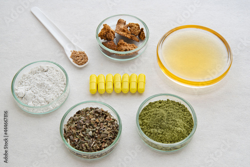 Close-up of medicines with ingredients in cups around them