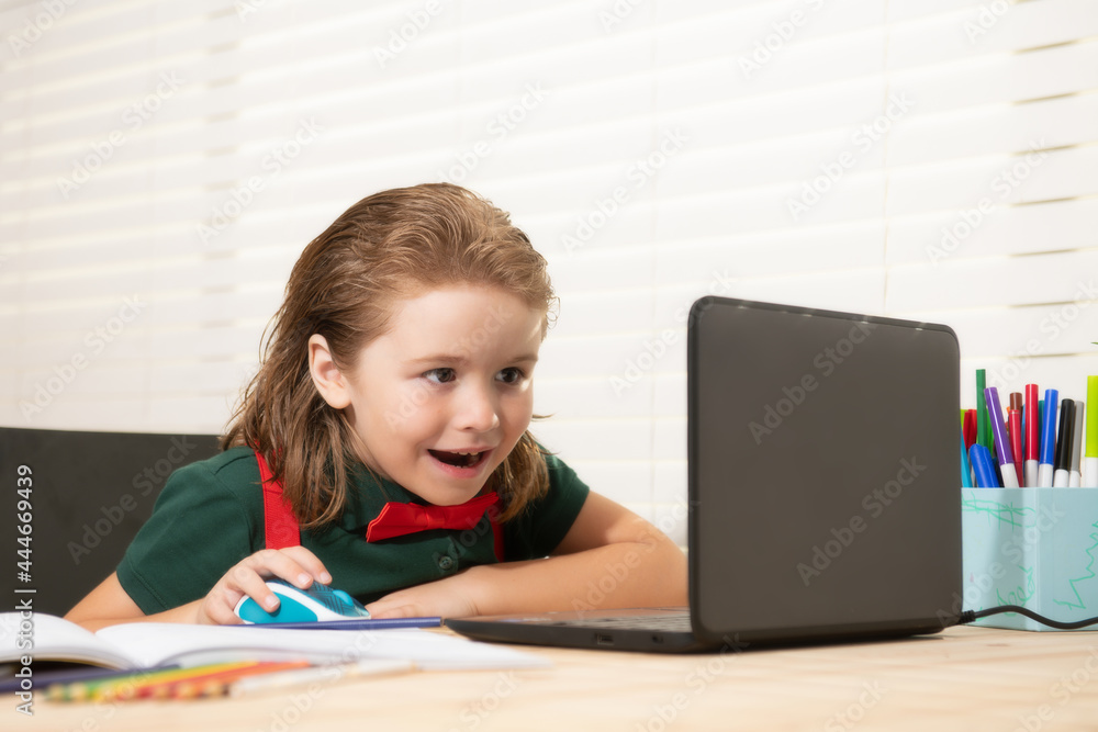 School boy with a happy smiling face studying and using computer laptop and writing on notebook. Nerd funny pupil. School boy with a happy smiling face studying and using computer laptop and writing on notebook. Nerd funny pupil.