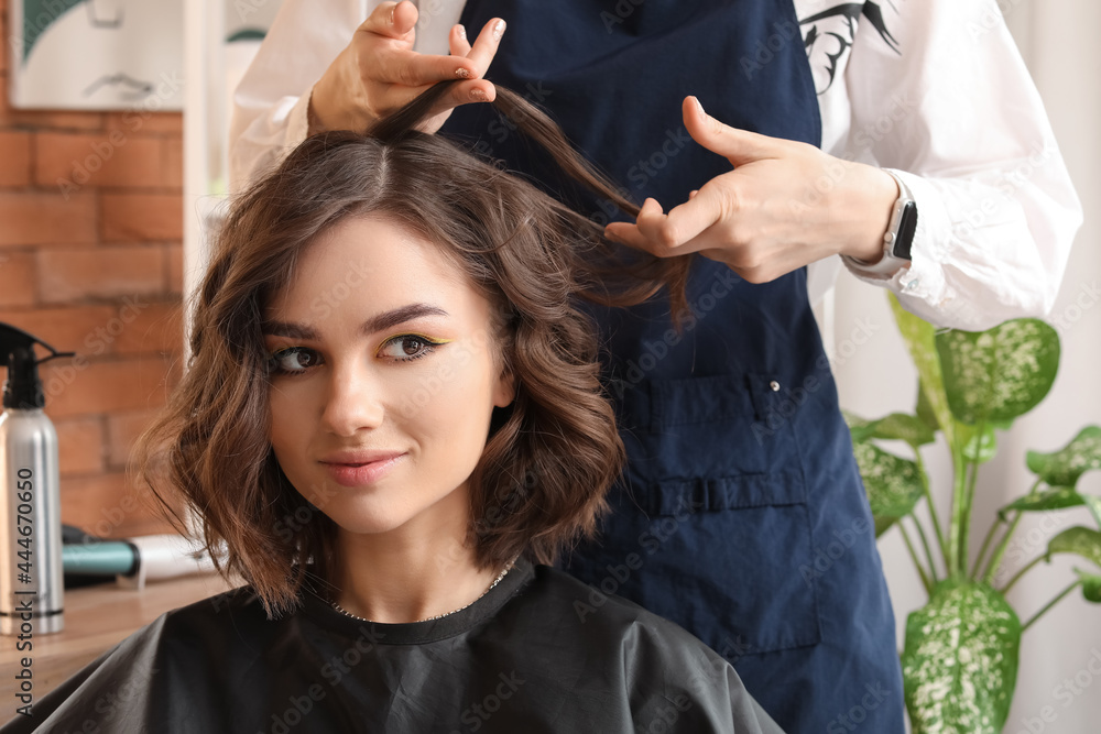 Fototapeta premium Female hairdresser working with client in beauty salon