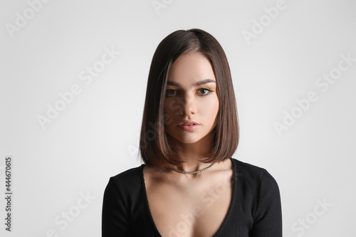 Beautiful young woman on light background