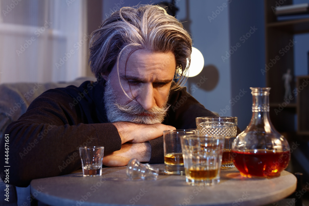 Drunk senior man late in evening at home Drunk senior man late in evening at home