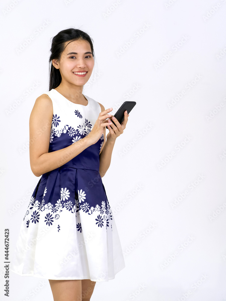 Young asian woman in white dress typing on mobile phone. Portrait on white background with studio light. Young asian woman in white dress typing on mobile phone. Portrait on white background with studio light.