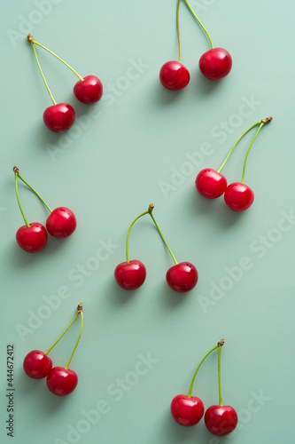 Bright red cherry berries on pastel green background. Flat lay  top view.