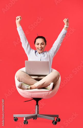 Happy female programmer with laptop on color background © Pixel-Shot