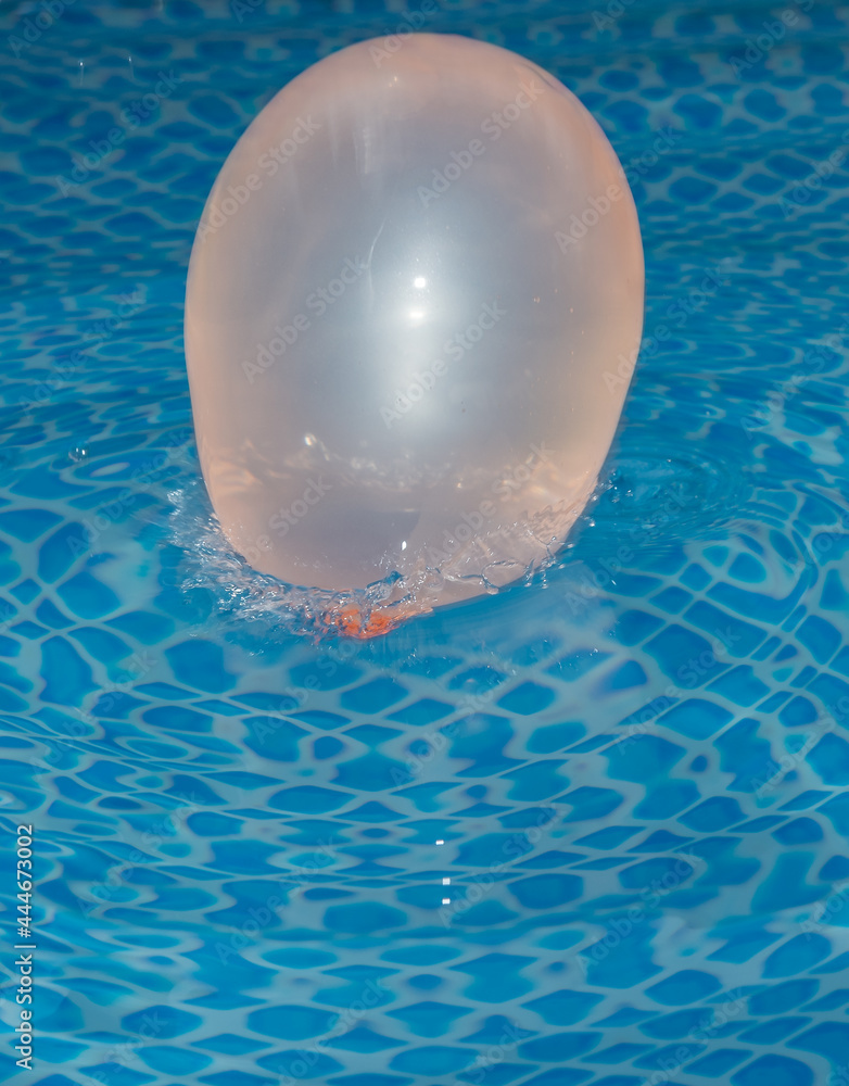 Wasserballon platscht in das Wasser