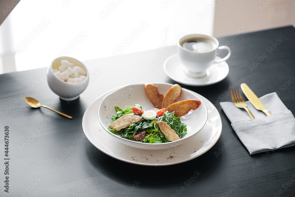 Plate with Caesar salad on table in restaurant Plate with Caesar salad on table in restaurant