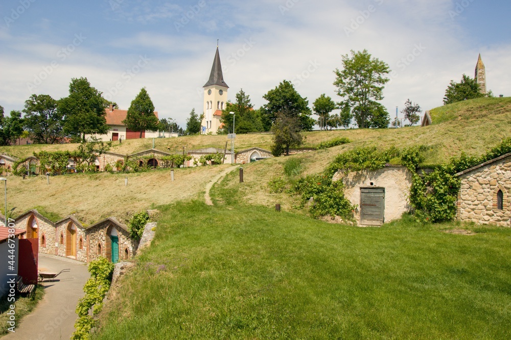 Moravian village Vrbice (south Moravian, Morava) with typical brick wine cellars and old historical church in middle of village during sunny summer day without people, Czech republic, Europe Moravian village Vrbice (south Moravian, Morava) with typical brick wine cellars and old historical church in middle of village during sunny summer day without people, Czech republic, Europe