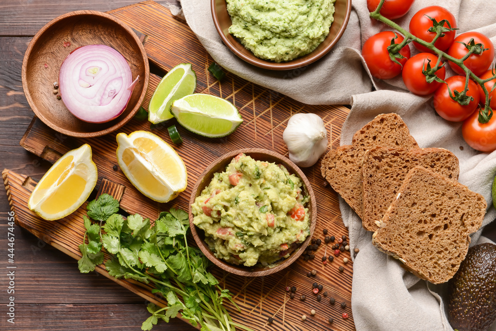 Composition with tasty guacamole in bowls on wooden background Composition with tasty guacamole in bowls on wooden background