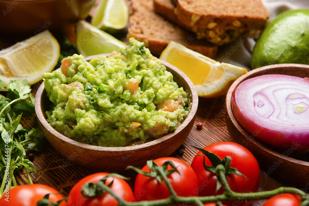 Bowl with tasty guacamole on table, closeup