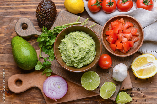 Composition with tasty guacamole and vegetables on wooden background