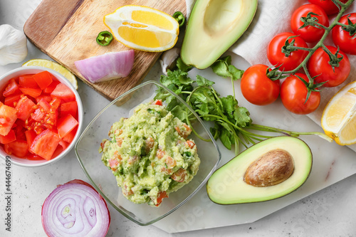 Composition with tasty guacamole and vegetables on light background