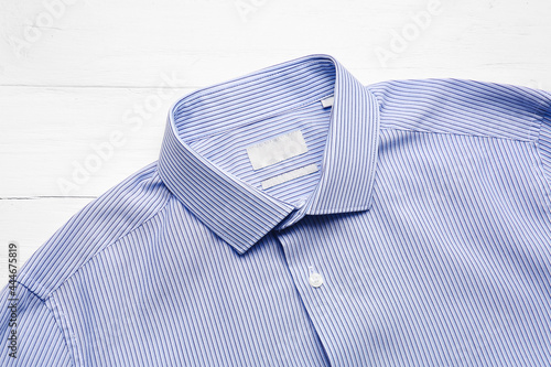 Stylish male shirt on light wooden background
