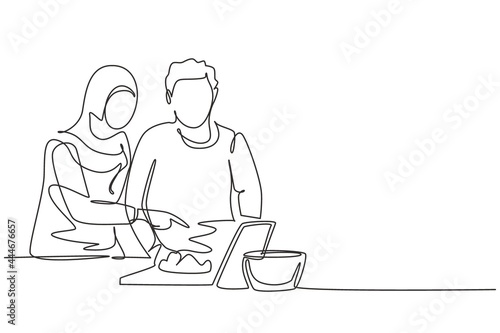 Single continuous line drawing romantic Arab couple cooking together while watching tutorial from tablet. Learn to cook with modern technology. Dynamic one line draw graphic design vector illustration