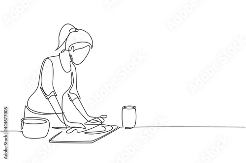 Single one line drawing young woman making cookie dough using rolling pin at kitchen table. Making bakery and homemade pizza at home. Modern continuous line draw design graphic vector illustration